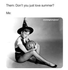 a woman sitting on the ground wearing a witches hat and holding a pumpkin in her hand