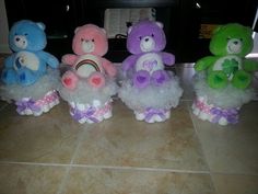 four stuffed teddy bears sitting on top of each other in tulle skirts and bows