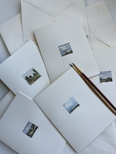 several white envelopes with pictures on them and a brush next to them, all lined up together