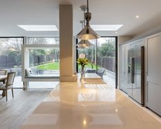 a large kitchen with an island countertop and glass doors leading to the back yard