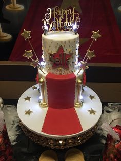 a red and white birthday cake with gold stars