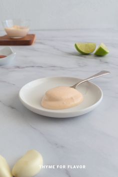 there is a spoon in a bowl on the table with limes and other ingredients