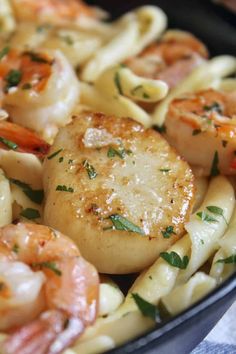 pasta with shrimp, scallops and parmesan cheese in a skillet