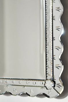 an ornately designed mirror is shown against a white background with silver trimmings