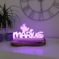 a lighted sign that says marous with a mickey mouse on it in front of a clock