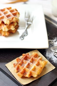 two waffles on a plate with forks