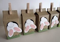 four little boxes with bunny ears on them are lined up in the shape of houses