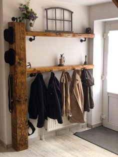 the coat rack is made from wood and has hooks on it, along with several coats