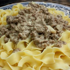 a close up of a plate of food with pasta and meat sauce on it,