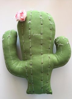 a green stuffed cactus with a pink flower on it