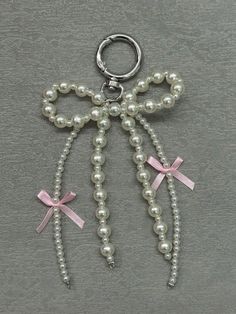 a key chain with pearls and bows on it