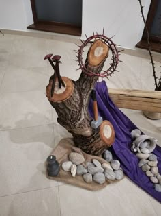 some rocks and branches on the ground next to a purple cloth with an iron decoration