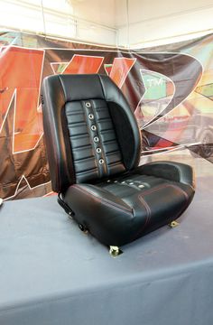 a black leather chair sitting on top of a table next to a wall covered in graffiti