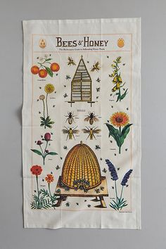 a tea towel with bees and honey on it hanging from the side of a wall