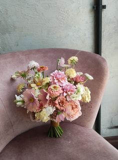 a bouquet of flowers sitting on top of a pink chair