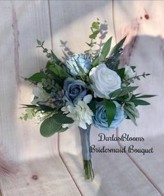 a bridal bouquet with blue and white flowers on a wooden background for the bridesmaid bouquet