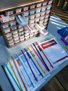 several stacks of books on a table with papers and pencils in front of them