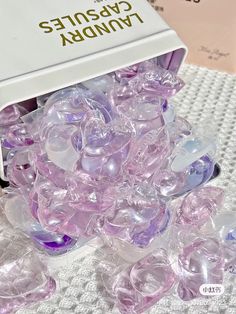 a box filled with lots of purple gummy bears on top of a white table