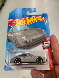 a hand holding a hot wheels die cast car