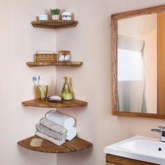 a bathroom with two shelves on the wall and one shelf above the sink is filled with towels