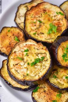 baked eggplant on a white plate with parsley