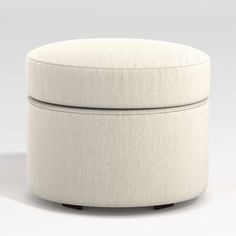 a white round ottoman sitting on top of a floor