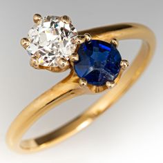 an engagement ring with two diamonds and a blue sapphire