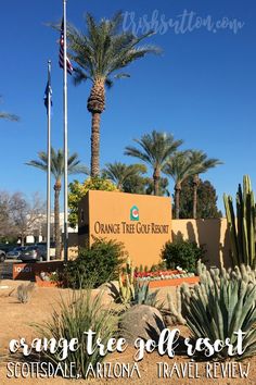 an orange tree golf resort sign in front of some palm trees and cacti