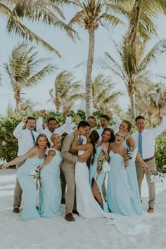 a group of people standing next to each other on top of a white sandy beach