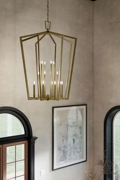 Fusing traditional and modern styles, the Abbotswell Chandelier takes a classic lantern design and updates it with an angular open frame and contemporary finishes. This versatile piece coordinates with a range of interior styles from transitional to modern farmhouse. Transitional Staircase Chandelier, Foyer Chandelier 2 Story Farmhouse, Two Story Entryway Lighting, Foyer Pendant Light Entryway, 2 Story Foyer Lighting, Foyer Chandelier 2 Story, Entry Light Fixture, Transitional Staircase, Foyer Pendant Lighting