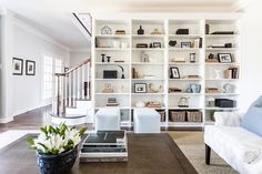 a living room filled with lots of furniture and bookshelves on top of each other