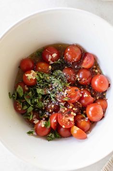 a white bowl filled with tomatoes and herbs