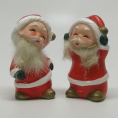 two santa claus figurines sitting next to each other