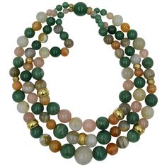 Three graduated strands of spectacular natural mined gemstones are linked together by 14 Karat Gold bands in this stunning Retro Modern Mid-Century bead necklace. The triple strand necklace features 43 Green Aventurine beads, 16 Rose Quartz beads, 14 Carnelian beads, 9 Agate beads, and 21 Gray Chalcedony beads. The largest bead is 20mm (.8 inches) in diameter. The combination of the natural gem colors with the warm 14 Karat gold braided beads is just magnificent! The necklace has been appraised Affordable Multi-strand Gold-tone Jewelry, Cheap Multi-strand Gold-tone Necklace, Watermelon Tourmaline Necklace, Gold Tassel Necklace, Red Tourmaline, Aquamarine Beads, Gold Bead Necklace, Snake Necklace, Carnelian Beads