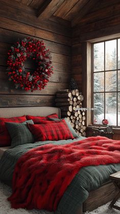 a bed with red and green comforters in a rustic cabin style bedroom decorated for christmas