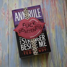 a book with a pink heart on it sitting on top of a wooden table next to a wall