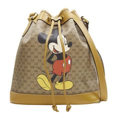 GUCCI DISNEY Candy GG Micky Mouse brown leather trim bucket bag Reference: TGAS/E00087 Brand: Gucci Designer: Alessandro Michele Model: Candy GG Collection: Disney Material: Canvas, Leather Color: Brown Pattern: Disney Closure: Drawstring Lining: Fabric Extra Details: Candy GG Bucket bag. Brown vintage GG monogram canvas. Brown genuine leather trim. Antique gold-tone hardware. Drawstring front. Adjustable shoulder strap. Made in: Italy CONDITION: Condition: Excellent, this item was pre-owned and is in excellent condition. Comes with: Designer tags. One dust bag. MEASUREMENTS: Width (width across base): 27cm / 10.5" Height (base to opening): 27cm / 10.5" Depth (side depth): 13cm / 5.1" Strap drop: 58cm / 22.6" This Gucci item is authentic. Disney Candy, Bag Reference, Gg Collection, Gucci Outfits, Gucci Designer, Functional Accessories, Canvas Shoulder Bag, Canvas Leather, Fashion Handbags