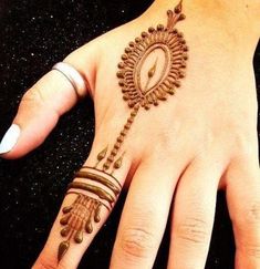 a woman's hand with hennap and ring tattoos on her left hand