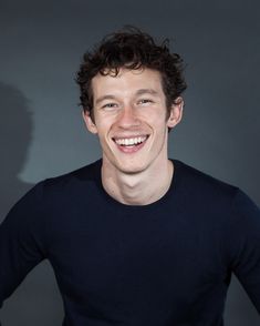 a young man smiling and wearing a black shirt