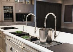 a kitchen with an island sink and stainless steel faucet