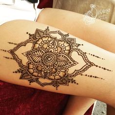 a woman's thigh with a henna tattoo on it