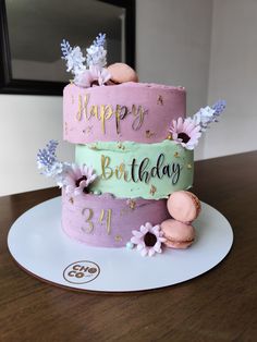 a three tiered cake decorated with flowers and the words happy birthday written on it