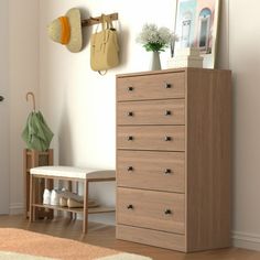 a wooden dresser sitting next to a white wall