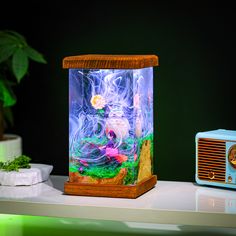 a fish tank sitting on top of a table next to a radio