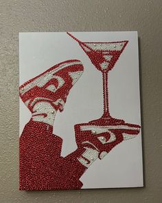 a red and white art piece with a man holding a martini glass in it's hand