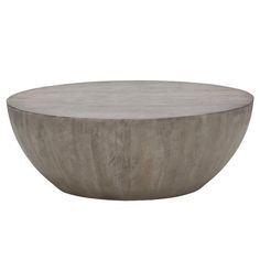 a round concrete table sitting on top of a white floor