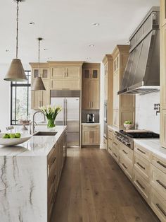 a large kitchen with wooden cabinets and marble counter tops