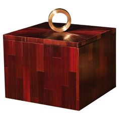 a wooden box with a gold ring on top