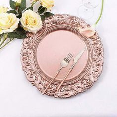 there is a plate with a fork and knife on it next to some yellow roses