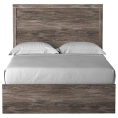 a bed with white sheets and wooden headboard